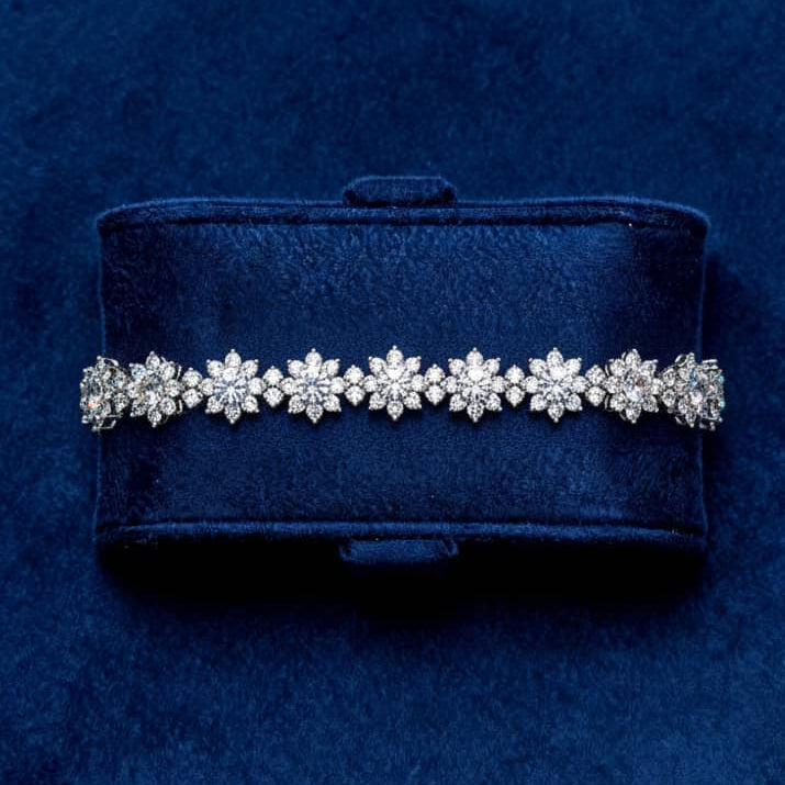 Diamond bracelet on a blue velvet box against a matching blue background