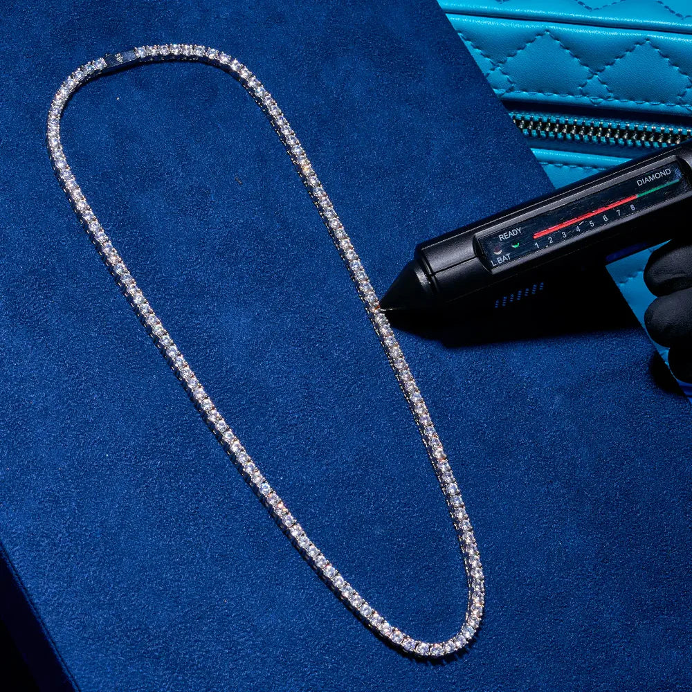 A gold tennis necklace with moissanite stones displayed on a black mannequin.